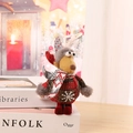 Dettaglio macro della renna di peluche con maglione scozzese rosso su libri decorativi - Cervo
