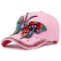 Detailed close-up of a pink denim baseball cap with colorful rhinestone butterfly design - Adjustable / Pink