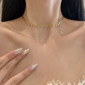 Golden heart-shaped choker necklace with openwork charms on a female model's neck - Gold Necklace