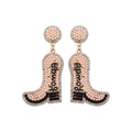 Detailed view of pink pearl cowboy boot earrings with Rowdy text and gold trim - Style 2 White Letter Rowdy