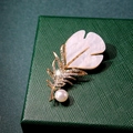 Golden feather brooch with shimmering pearls and sparkling cubic zirconia on green velvet - Shell Texture Leaf