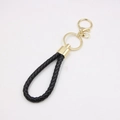 Détail du porte-clés en cuir tressé noir avec crochet et anneau en métal doré - Noir