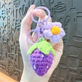 Handmade crochet strawberry keychain in purple with matching plastic clasp and flower detail - Purple Strawberry Flower