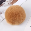 Close-up of 8cm tan faux rabbit fur pom pom with soft fluffy texture on white background - Camel