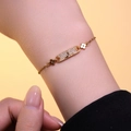 Elegant gold zircon bracelet featuring a dolphin tail motif shown on a woman wrist - Gold Bracelet (S1119)
