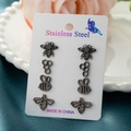 Detailed macro view of four pairs of black stainless steel bee and honeycomb stud earrings - Black
