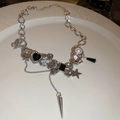 Dettaglio della collana argentata con ciondoli a farfalla, cuore e stella su piatto bianco - Farfalla di Perle d'Argento