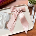 Close-up of pink satin double bow hair clip with ribbons on a wooden surface - Gold Pink 09