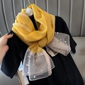 Detail of yellow silk-like scarf with pearl embellishments on a sheer white fabric end - Yellow