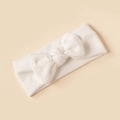 Close-up of white soft cotton baby headband with a delicate ribbed bow decoration - White