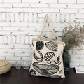 Minimalist canvas tote bag with leaf prints on a black wooden table with decor - Leaves (Canvas Style) / Beige