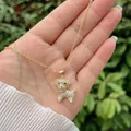 Close-up of 18K gold plated dog pendant necklace with white zircons and red bow detail - Iced Out Dog (Style 4)