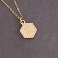 Macro detail of golden hexagonal pendant with embossed letter Z on dark stone texture - Letter Z (26#Z)