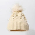 Winter-Strickmütze mit weichem Bommel und Metall-Nieten in cremeweißer Farbe - Beige