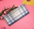 Dettaglio dell'astuccio in tela a quadri blu e gialli con cerniera su sfondo rosa - Scozzese Blu e Giallo