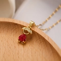Vista dettagliata del ciondolo a bambina dorato con gemma a cuore rosso e pietre zirconi - Ragazza in Zircone Rosso Scuro (23970)