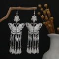 Orecchini etnici a farfalla d'argento con nappe su sfondo artistico scuro e raffinato - E7957 (Nappa Lunga Farfalla Traforata) / Argento