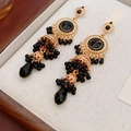 Primer plano de pendientes Jhumka vintage dorados con cuentas negras en estuche de madera - Negro Dorado
