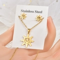 Close-up of golden stainless steel jewelry set featuring anchor and helm nautical charms - Ship Wheel & Anchor