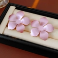 Dettaglio di orecchini a forma di fiore rosa opaco su una scatola di velluto crema - Rosa