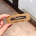 Rectangle khaki PU leather hair clip held by hand showing smooth matte finish - Khaki