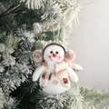 White snowman Christmas ornament with brown earmuffs and plaid scarf on tree - Snowman