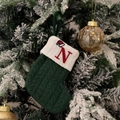 Green knitted Christmas stocking featuring a red letter N and festive hat embroidery - Green/Letter N