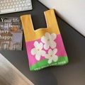 Dettaglio di una borsa tote in maglia colorata con margherite e slogan sulla scrivania - Floreale giallo