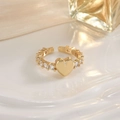 Macro shot of gold heart ring with pavé cubic zirconia accents on a silk background - Gold Heart Pave Sides Style (JZ0150)