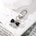 Detail of silver keychain with black crystal bow pendant on minimalist stone - Black Rhinestone Silver Bow Knot