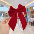 Large red velvet bow hair clip for girls on a white card display with blurred background - Large Diagonal Bow / Red