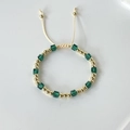 Detail of 18k gold plated beads and green crystal cube on adjustable drawstring bracelet - Emerald