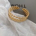 Detail eines goldenen dreilagigen Perlen-Armreifs mit strukturierter Metalloberfläche - Dreilagiger Rundperlen-Offen-Stil (Gold)