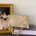 Handmade woven straw beach bag with pearl chain and seashell charms on a book - Milky White