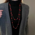Double-layered long necklace featuring vibrant red beads and silver links on grey knitwear - Red Pearl + Silver-Tone Chain