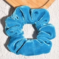 Detailopname van de koningsblauwe fluwelen scrunchie met zachte geplooide textuur - Blauw