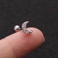 Macro shot of silver crescent moon piercing stud with tiny cubic zirconia on a fingertip - Moon Silver - 1PC
