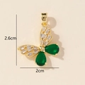 Detail view of gold butterfly pendant with white baguette diamonds and green gemstones - Gold Green White Butterfly