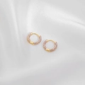 Macro shot of gold-plated hoop earrings with lavender enamel inlay on silk background - Purple