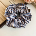 Detailed view of a striped fabric scrunchie on a vintage book with elegant roses - Coffee Stripe Scrunchie