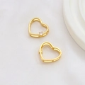 Makro-Detail von vergoldeten Herz-Anhängern mit kleinen funkelnden Zirkonia-Steinen - 18K Gold