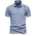 Detalle del polo azul acero con textura de algodón piqué y bordados de flechas - L / Azul Grisáceo
