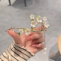 Elegant cherry blossom hair clip with pearls and golden tassels in a hand-held view - Ancient Style Cherry Blossom Pearl Tassel Clip