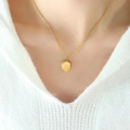 Minimalistische goldene geometrische Hexagon-Halskette getragen am Model mit weißem Strickpullover - Unregelmäßig Geometrisch Gebürstet / Gold