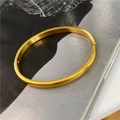 Minimalist 18K gold plated titanium steel oval bangle with polished finish and hinge clasp - Gold