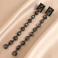 Detailed macro view of black rectangular crystal tassels on elegant champagne silk fabric - Long Tassel Dangle Earrings / Black (Silver Earring Post)