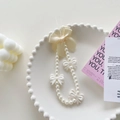 Detail of cream pearl phone charm featuring a delicate ribbon bow and bead textures - Pearl Gauze Bow Bracelet