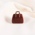 Miniature handbag pendant crafted from brown goldstone with a metallic golden handle - Gold Sandstone