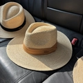 Primo piano di cappelli fedora in rafia fatti a mano con fasce marroni e nere su pelle - M(56-58cm) / Arancione