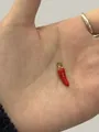 Miniature red chili pepper pendant with gold ring held in palm for size reference - Red Chili (24099)